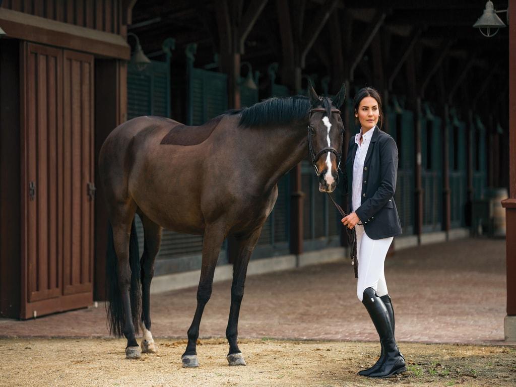 Woman in a riding jacket with horse